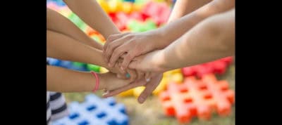 Children holding hands in a supportive group activity.