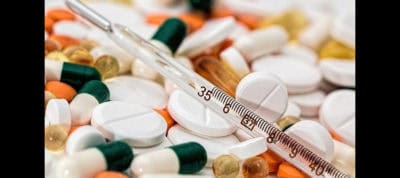Close-up of pills and syringe used in opioid addiction management.