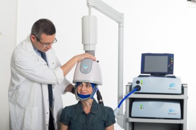 TMS treatment being administered to a patient by a healthcare professional.