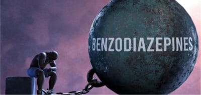 Person contemplating dangers of mixing stimulants and benzodiazepines.