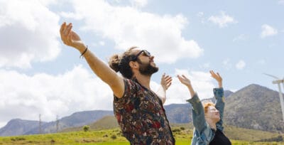 Man and woman enjoying outdoor sunshine and fresh air in a scenic mountain landscape.