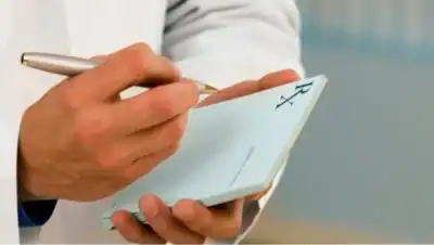 Person holding a notepad and pen, writing or reviewing notes related to mental health and treatment.