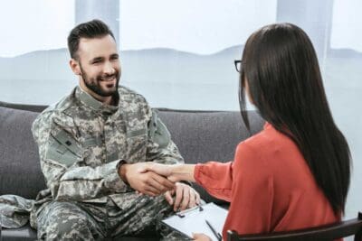Veteran and therapist shaking hands during ketamine treatment session.