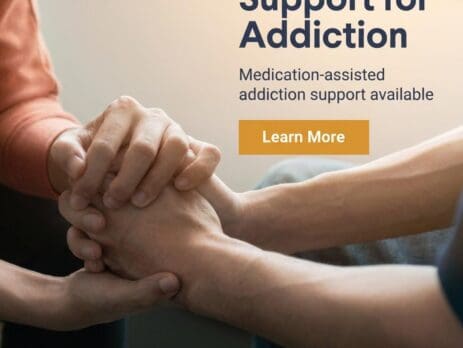 Hands clasped in support during addiction treatment session.